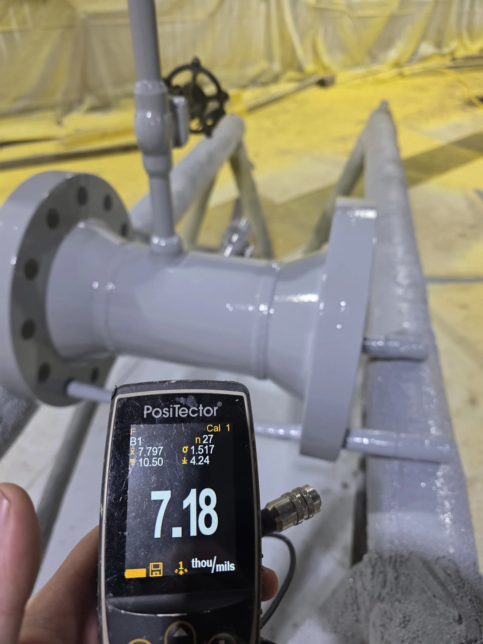 DFT measurement showing 7.18 mils coating thickness on industrial pipe spool